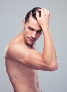 Kaslı adam gri arka plan üzerinde poz