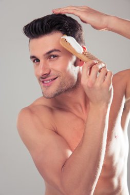 Gülümseyen adam onun saç için saç spreyi uygulama