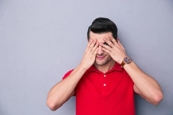 Casual man die betrekking hebben op zijn ogen met vingers — Stockfoto