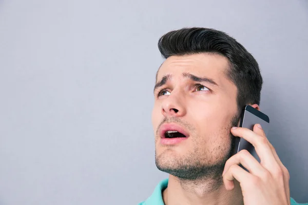 Pensive young man talking on the phone — Stock Photo, Image