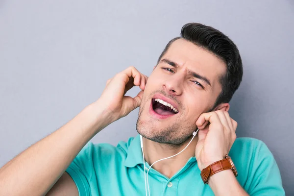 Joven cantando en auriculares — Foto de Stock