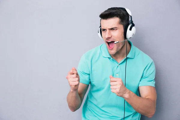 Joven cantando en auriculares — Foto de Stock