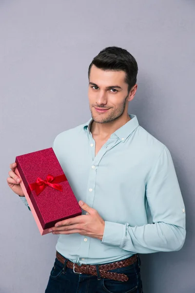 Sorrindo homem casual segurando caixa de presente — Fotografia de Stock