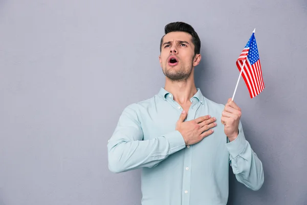 Patriotic young man holding US flag — Stock Photo, Image