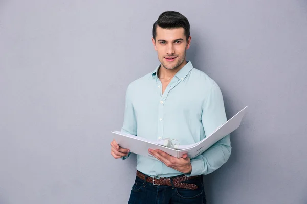 Young man standing with folder — Stock Photo, Image