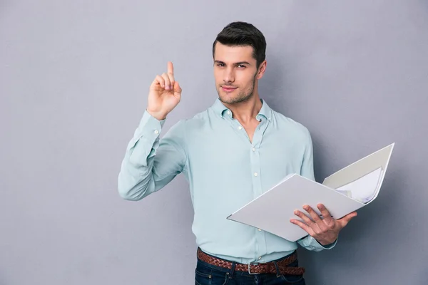 Uomo che tiene la cartella e punta il dito verso l'alto — Foto Stock