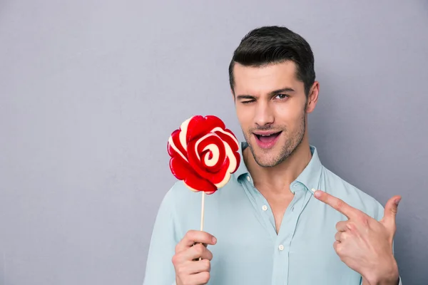 Porträtt av en stilig man håller lollipop — Stockfoto