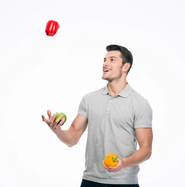 Happy young man juggling pepper — Stock Photo, Image