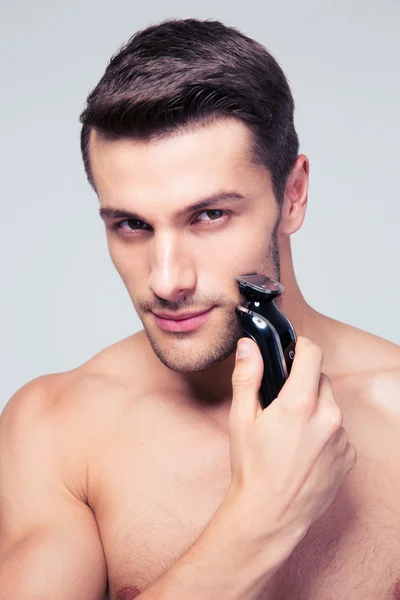 Hombre guapo afeitándose con afeitadora eléctrica — Foto de Stock