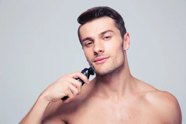 Jóképű férfi, elektromos borotva borotválkozás — Stock Fotó