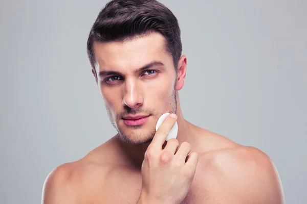 Hombre limpieza de la piel de la cara con almohadillas de algodón bateo — Foto de Stock