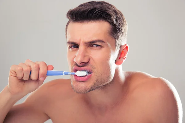 Retrato de un hombre guapo cepillándose los dientes — Foto de Stock