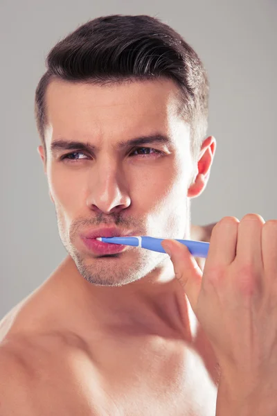 Joven guapo cepillándose los dientes — Foto de Stock