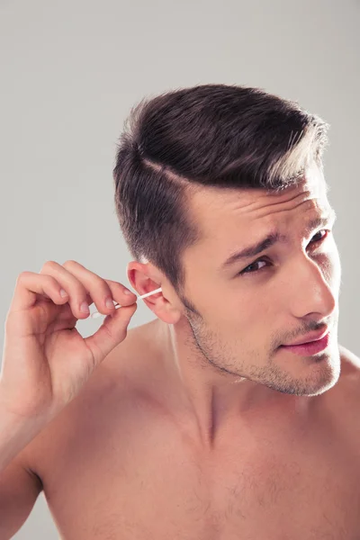 Man cleans his ear with a cotton swab — Stock Photo, Image