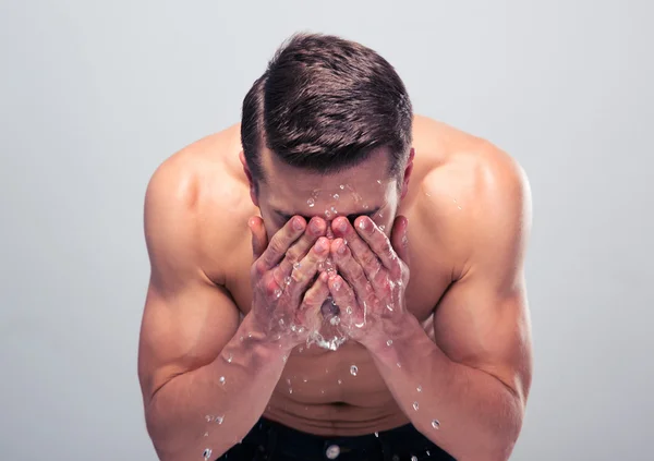 Musclé homme pulvérisation d'eau sur son visage — Photo