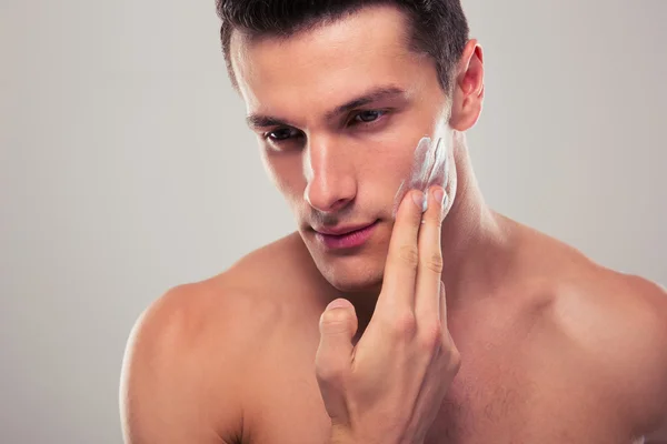 Hombre aplicando crema facial — Foto de Stock