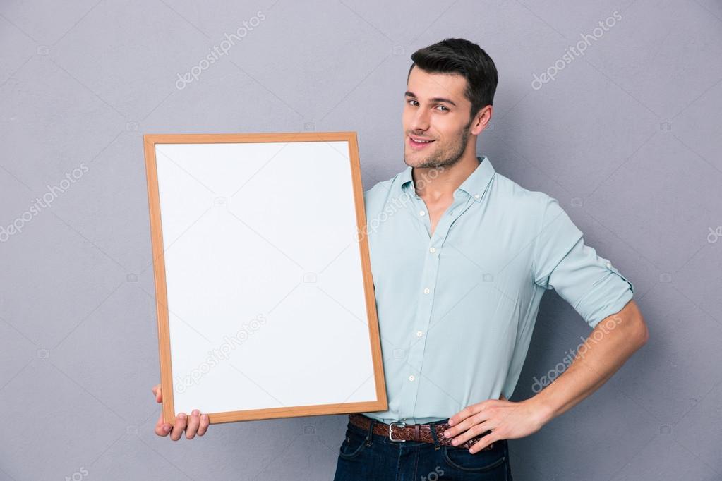 Young man holding blank board