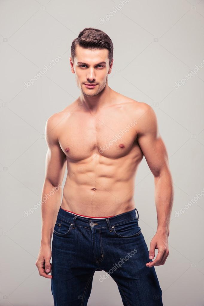 Sexy confident man posing over gray background — Stock Photo ...