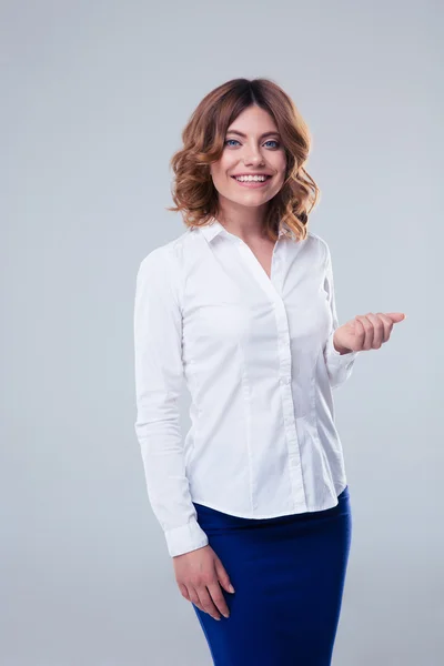 Smiling businesswoman standing over gray background — Stock Photo, Image