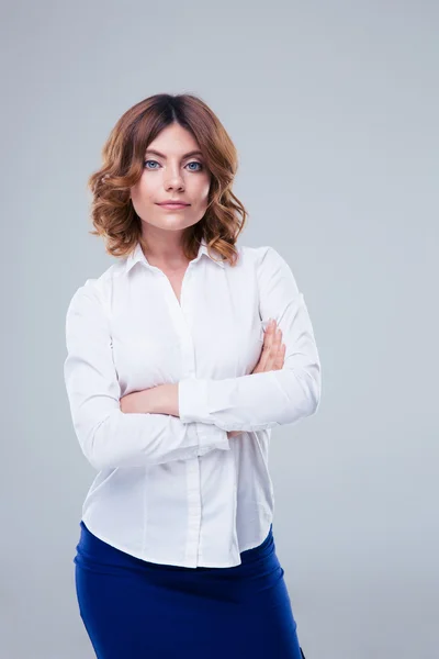 Heureuse femme d'affaires debout avec les bras croisés — Photo