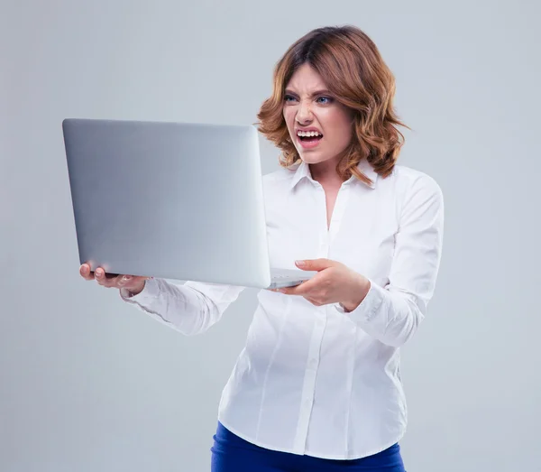 Businesswoman with disgusted emotion holding laptop — Stock Photo, Image