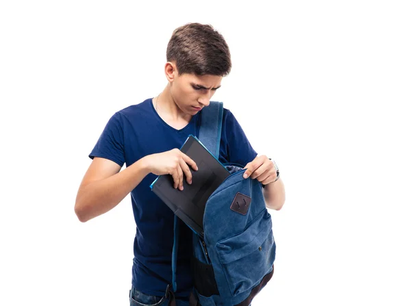 Male student putting folder in backpack — Stock Photo, Image
