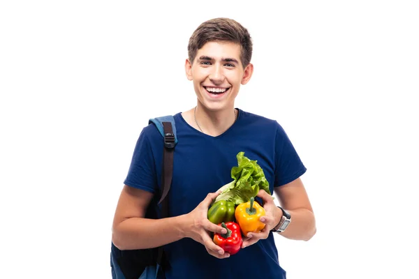 Estudante masculino alegre segurando legumes — Fotografia de Stock