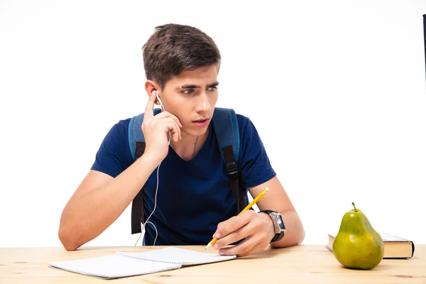 Estudiante masculino sentado en el examen con auriculares —  Fotos de Stock