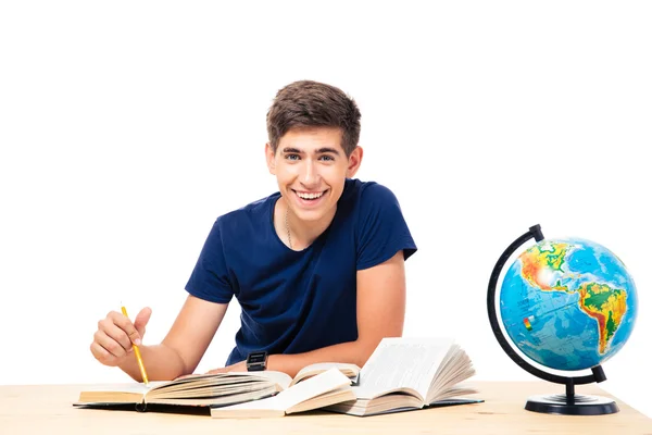 Mannelijke student zitten aan de tafel met boeken — Stockfoto