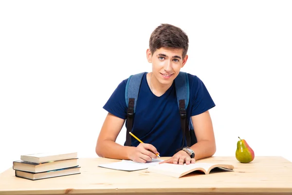 Feliz estudiante masculino sentado en la mesa — Foto de Stock