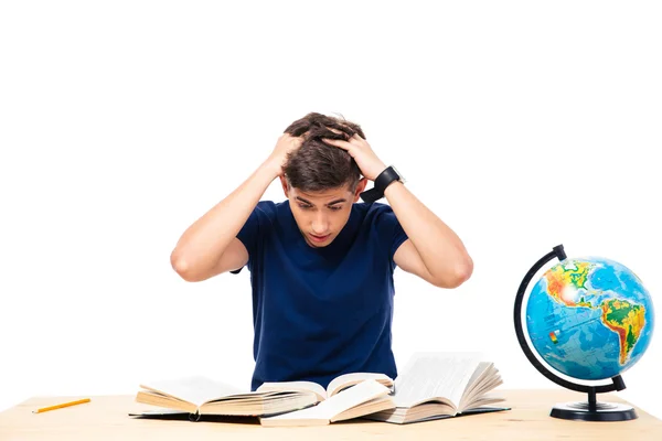 Estudiante cansado sentado a la mesa y leyendo libros —  Fotos de Stock