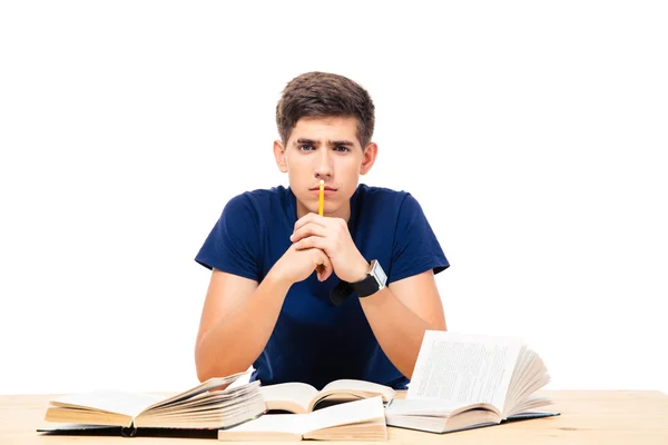 Estudante do sexo masculino sentado à mesa com livros — Fotografia de Stock