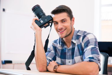 fotoğraf makinesi ile masada oturan adam 