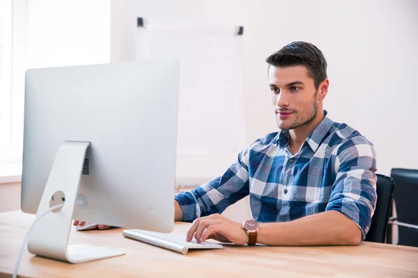 Schöner Geschäftsmann mit PC am Tisch — Stockfoto