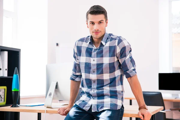 Geschäftsmann sitzt im Amt auf dem Tisch — Stockfoto