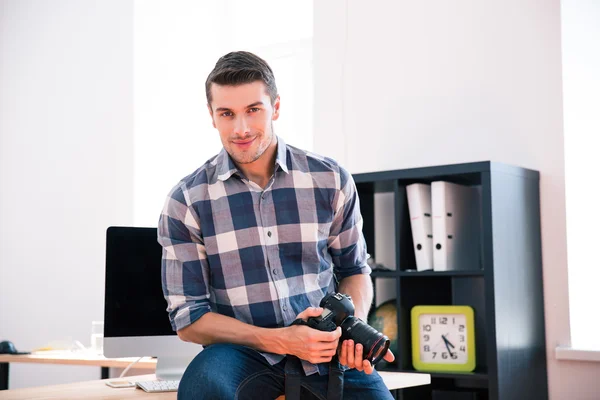 Sonriente hombre sosteniendo la cámara de fotos — Foto de Stock