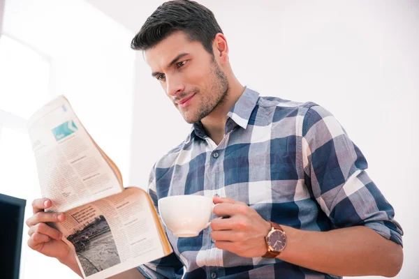 新聞を読むと、オフィスでコーヒーを飲むビジネスマン — ストック写真
