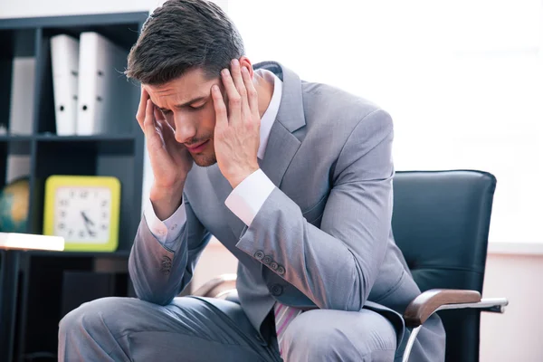 Nachdenklicher Geschäftsmann sitzt auf Bürostuhl — Stockfoto