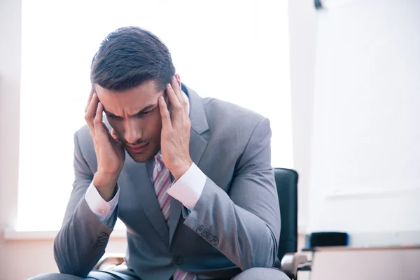 Pensive businessman sitting on office chair — Stock Photo, Image