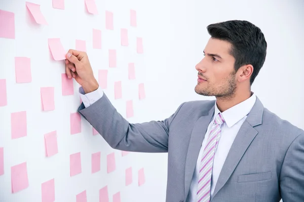 Businessman looking on sticker at wall — Stock Photo, Image