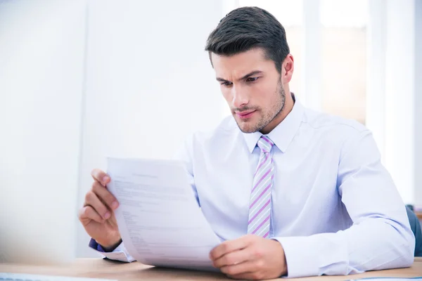 Zakenman aan de tafel document leest — Stockfoto