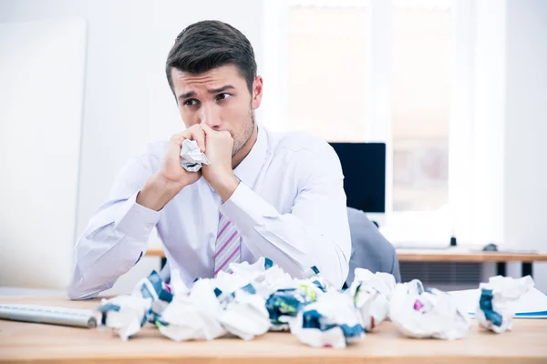 Empresário pensativo sentado à mesa no escritório — Fotografia de Stock