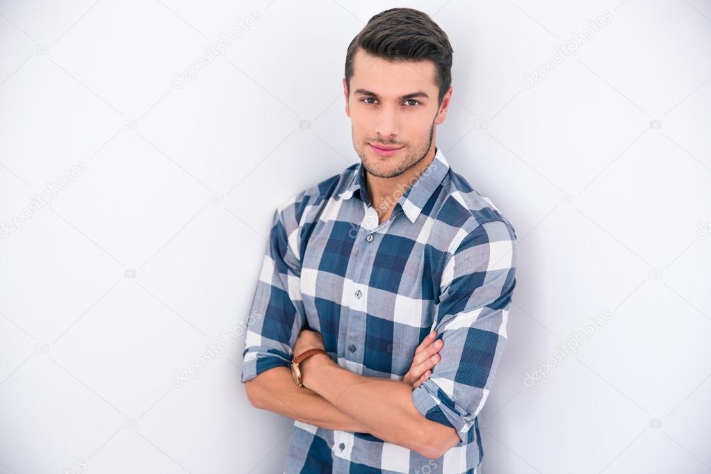 Handsome young man standing with arms folded 