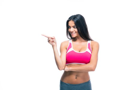 Happy fitness woman pointing finger away