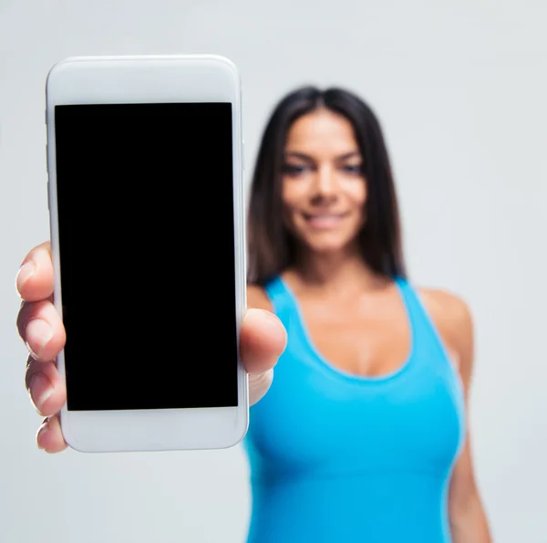 Mujer feliz mostrando pantalla de teléfono inteligente en blanco Imagen de stock