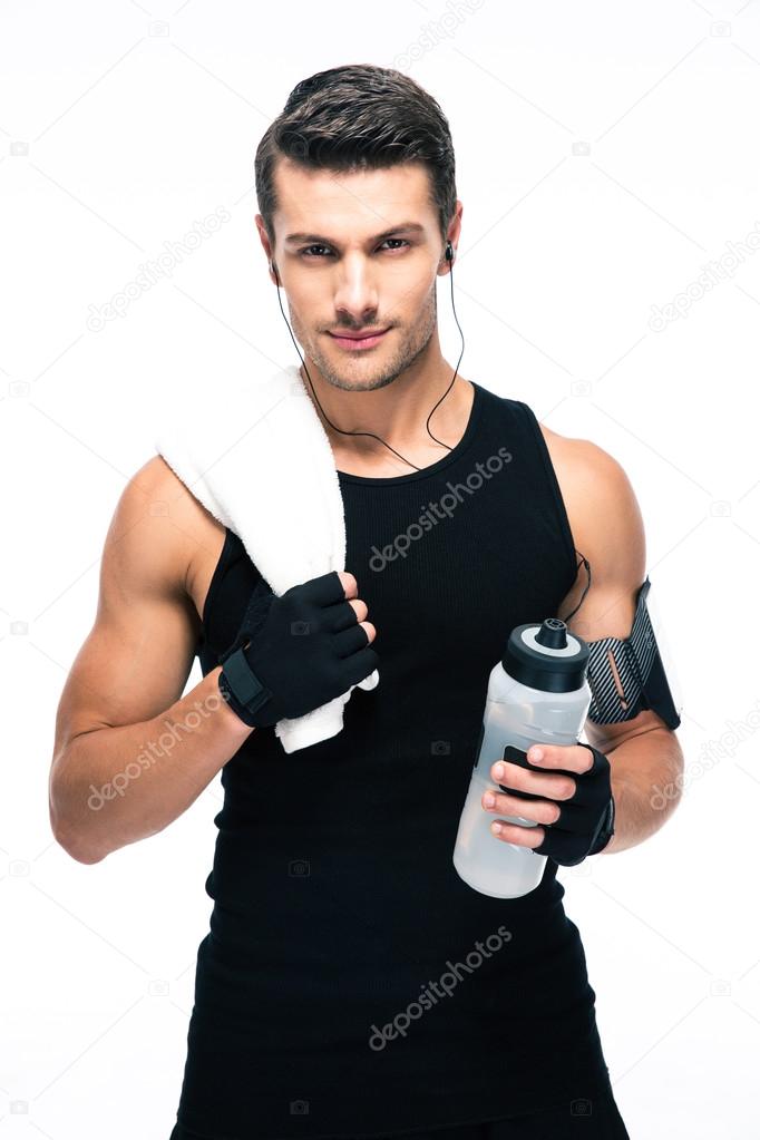 Handsome fitness man holding towel and bottle with water