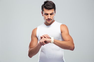 Handsome fitness man using smart watch
