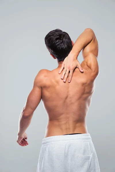 Rear view portrait of a muscular man with neck pain — 스톡 사진