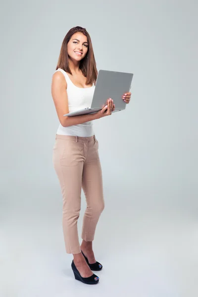 Mujer feliz de pie con el portátil —  Fotos de Stock