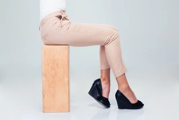Woman sitting on wooden box — Stok fotoğraf